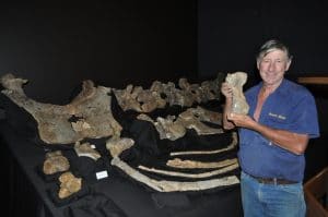 David Elliott tenant un orteil fossile de Savannasaurus elliottorum.