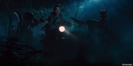 Chris Pratt en moto avec des velociraptors.